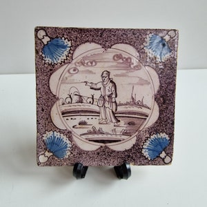 Nederlandse antieke tegel - delft blauw met mangaan paars gesprenkelde tegel, in geschulpte blauwe cirkel, herderin in landschap 1675-1725