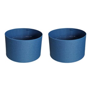May include: Two blue fabric round planters. The planters are made of a textured fabric and have a round shape.