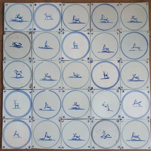 May include: A collection of antique ceramic tiles, each featuring a blue and white design. The tiles are square, with a central circular motif depicting various deer poses. The borders have a blue ring and decorative corner elements.