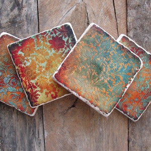 May include: Four square ceramic coasters with a colorful floral pattern in shades of red, orange, yellow, green, and blue. The coasters have a rustic, vintage look.