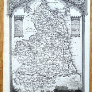 Peut inclure: Une carte ancienne en noir et blanc de Northumberland, en Angleterre, avec des routes, des villes et des éléments géographiques détaillés. La carte comprend des bordures décoratives, des écussons et le texte "Northumberland".