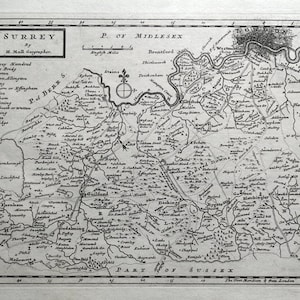 May include: A vintage black and white map of Surrey and Middlesex, England. The map shows the counties' boundaries, rivers, and towns. The title "Surrey" is at the top left corner, and "P. of Middlesex" is at the top right corner. The map is surrounded by a decorative border.
