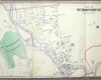 May include: An antique map of St. Johnsbury, Vermont, showing the town's streets, buildings, and river. The map is printed on a cream-colored paper with brown and green ink. The map is titled "Part of St. Johnsbury" and includes a compass rose.