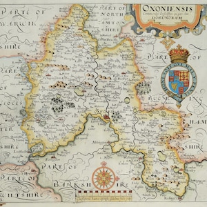 May include: An antique map of Oxfordshire, England, with a detailed depiction of towns, villages, and rivers. The map is surrounded by a decorative border and includes a compass rose and a scale bar. The text "OXONIENSIS" is prominently displayed at the top of the map.