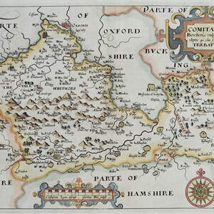 May include: A detailed, antique map of a region, featuring hand-drawn illustrations and text. The map is colored with shades of yellow, orange, and green, with text labels indicating towns and geographical features. A compass rose is in the lower right corner.