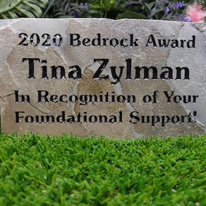 Puede incluir: Una placa de piedra gris con el texto "2020 Bedrock Award Tina Zylman In Recognition of Your Foundational Support!"