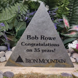 May include: A gray triangular stone plaque with the text "Bob Rowe Congratulations on 35 years!" and a logo for Iron Mountain.