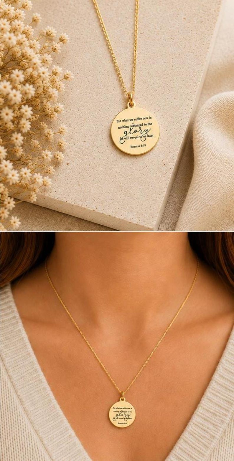 May include: A gold-toned necklace featuring a circular pendant engraved with the text: Yet what we suffer now is nothing compared to the glory he will reveal to us later Romans 8:18. The pendant hangs from a delicate gold-toned chain.