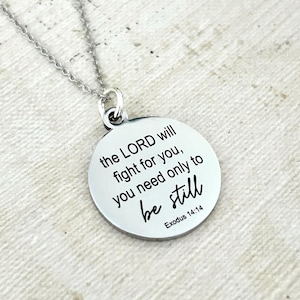 May include: A silver necklace with a round pendant that reads "the LORD will fight for you, you need only to be still Exodus 14:14".
