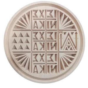 May include: A round wooden stamp with a carved design featuring a grid of letters and geometric shapes. The letters are in a stylized font and the shapes are triangles and rays.