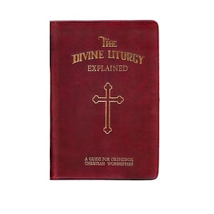 Pu&ograve; includere: Un libro bordeaux intitolato "The Divine Liturgy Explained" con lettere dorate e una croce dorata. La copertina del libro include anche il testo "A Guide for Orthodox Christian Worshippers".