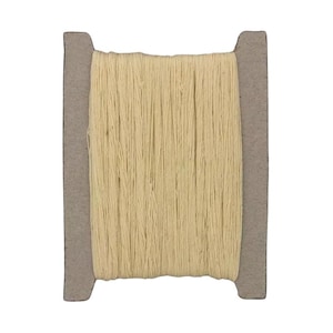 Może przedstawiać: Szpulka beżowej nici nawiniętej na kartonowy rdzeń.