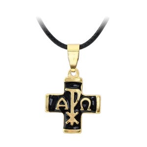Pode incluir: Um colar dourado com um pingente de cruz de esmalte preto que apresenta as letras gregas Alfa, Omega e Chi Rho. O colar tem um cordão preto.