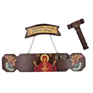 Peut inclure: Une enseigne en bois avec une icône religieuse de la Vierge Marie et de l'enfant. L'enseigne est brune avec des accents dorés et comporte une bannière avec le texte "ΥΠΕΡΑΓΙΑ ΘΕΟΤΟΚΕ ΣΩΣΟΝ ΗΜΑΣ".