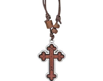 May include: A brown leather cord necklace with wooden beads and a silver-toned cross pendant. The cross has a red wood inlay with Greek lettering.