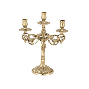 Peut inclure: Un chandelier doré à trois bras avec des détails ornés d'inspiration florale. La base et les bras présentent des motifs complexes, et les bougeoirs sont conçus pour contenir trois bougies. Le chandelier est un objet décoratif.