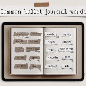 May include: An open journal with torn paper labels featuring common bullet journal words like "numbers," "playlist," and "read." The words are in a mix of fonts and colors, with the title "Common bullet journal words" above.