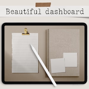 May include: A digital tablet displays a minimalist workspace. A notepad with a gold clip, a stylus, a beige book labeled "STICKER BOOK", and two blank squares are arranged on the screen. The text "Beautiful dashboard" is above the tablet.