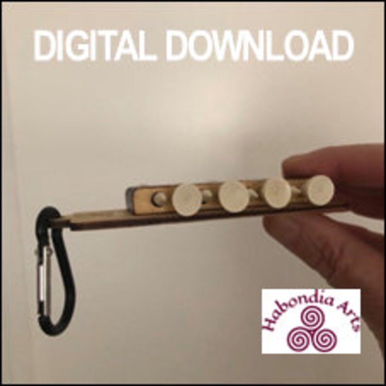 May include: A wooden keychain with a small wooden box and six white pegs. The keychain has a black carabiner clip and the text "Habondia Arts" is printed on the wooden box.