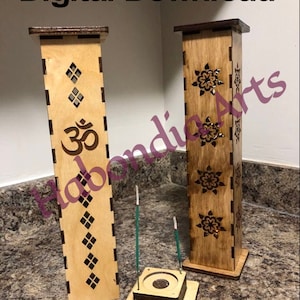 May include: Two wooden incense burner towers with intricate designs. The tower on the left has a diamond pattern and the Om symbol. The tower on the right has a floral pattern. Both towers are on a wooden base with a small round hole in the centre.