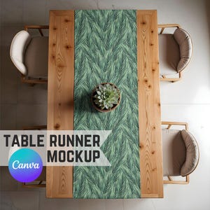 May include: A green and white table runner with a leafy pattern. The runner is laid out on a wooden table with chairs on either side. The table runner is a great way to add a touch of nature to your dining room.