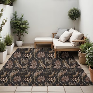 May include: A black and brown floral patterned outdoor rug with a white couch and two pillows, a wooden coffee table, and potted plants in the background.