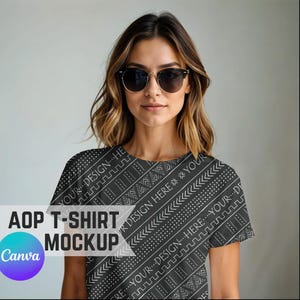 Può includere: Un mockup di maglietta AOP nera con un motivo geometrico bianco. La maglietta presenta il testo "YOUR DESIGN HERE" e "AOP T-SHIRT MOCKUP" con il logo Canva.