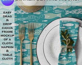 May include: A white dinner plate with a gold fork and knife on a teal tablecloth with a pattern of white fish. A folded napkin with the same pattern is on the plate.