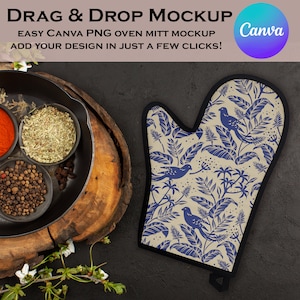 May include: A blue and white oven mitt with a floral pattern featuring birds and leaves. The mitt is on a dark background with a wooden cutting board and spices in bowls.