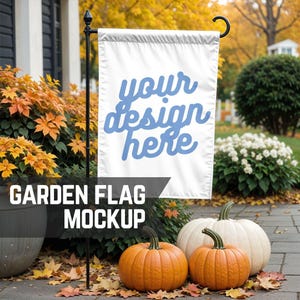 May include: A white garden flag mockup with the text "your design here" in blue. The flag is displayed on a black metal pole in front of a house with pumpkins and autumn foliage.