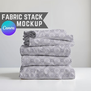Puede incluir: Una pila de tela doblada con un patrón geométrico gris y blanco repetitivo. La tela está apilada cuidadosamente, con la pieza superior ligeramente arrugada. Las palabras "FABRIC STACK MOCKUP" están en texto gris encima de la tela.