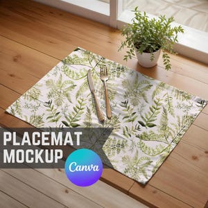 May include: A white placemat with a green leafy pattern and a gold fork and knife on top. The placemat is on a wooden table. The text "PLACEMAT MOCKUP Canva" is visible in the bottom left corner of the image.