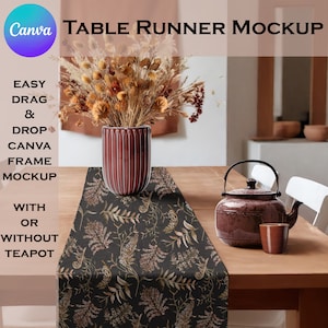 May include: A black table runner with a floral pattern featuring brown and beige leaves. The runner is on a wooden table with a brown teapot and a brown cup. The table runner is styled with a vase of dried flowers.