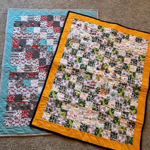 Puede incluir: Dos colchas de retazos hechas a mano. Una colcha es azul con un patrón geométrico de cuadrados rojos, blancos y grises. La otra colcha es amarilla con un patrón geométrico de cuadrados verdes, blancos y marrones. La colcha tiene el texto "Heart is a Home" repetido en todo.