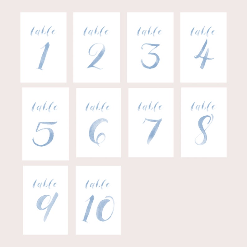 May include: Ten watercolor table number cards with blue calligraphy. The cards are numbered 1 through 10. Each card has the word "table" written above the number.