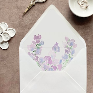 May include: A white envelope with a floral design on the inside. The design features purple and blue watercolor flowers.