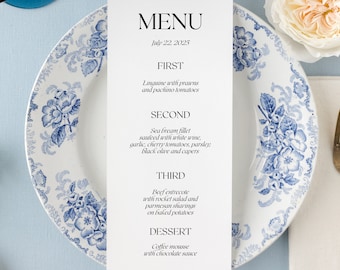 May include: A white menu card with black text listing the courses for a meal. The menu includes: First - Linguine with prawns and pachino tomatoes, Second - Sea bream fillet sauced with white wine, garlic, cherry tomatoes, parsley, black olive and capers, Third - Beef entrecote with rocket salad and parmesan shavings on baked potatoes, Dessert - Coffee mousse with chocolate sauce. The menu is dated July 22, 2025.