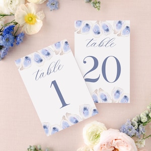 May include: Two white table number cards with blue oyster illustrations and the text "table" and the numbers "1" and "20" in blue.