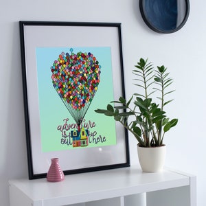 Peut inclure: Une impression encadrée avec une illustration colorée d'une maison attachée à un groupe de ballons, avec le texte "adventure is out there" en dessous. L'impression est sur une étagère blanche avec une plante en pot et un petit vase rose.