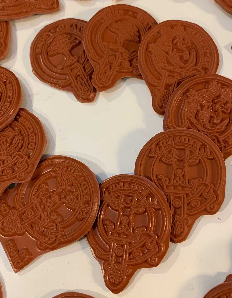 Pode incluir: Uma cole&ccedil;&atilde;o de 12 carimbos de borracha marrom com v&aacute;rios desenhos, incluindo uma &aacute;rvore, um veado e um p&aacute;ssaro. Os carimbos est&atilde;o dispostos em c&iacute;rculo sobre uma superf&iacute;cie branca.