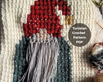 Op de afbeelding: Een close-up van een gehaakte gnome met een rode muts, een grijze baard en een groene en witte achtergrond. De tekst "Tunisian Crochet Pattern PDF" is zichtbaar in de afbeelding.
