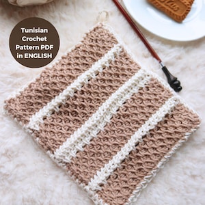 Peut inclure: Un dessous de plat en crochet tunisien à rayures brunes et blanches. Le dessous de plat est réalisé avec un point texturé. Le texte "Tunisian Crochet Pattern PDF in ENGLISH" est sur un cercle brun dans le coin supérieur gauche de l'image.