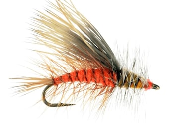 May include: A fishing fly lure featuring a bright orange body wrapped with thin thread, adorned with long, wispy tan and grey feathers extending from the top and sides, attached to a curved metal hook with a small eyelet at the front.