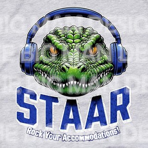 May include: A gray t-shirt with a green alligator wearing blue headphones. The alligator has a toothy grin. The text "STAAR" is printed in blue below the alligator. The text "Rock Your Accommodations!" is printed in blue below the word "STAAR".