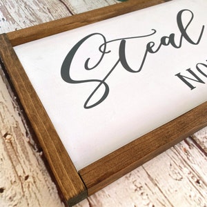 May include: A wooden framed sign with the text "Steal My Sunshine" in a gray cursive font.