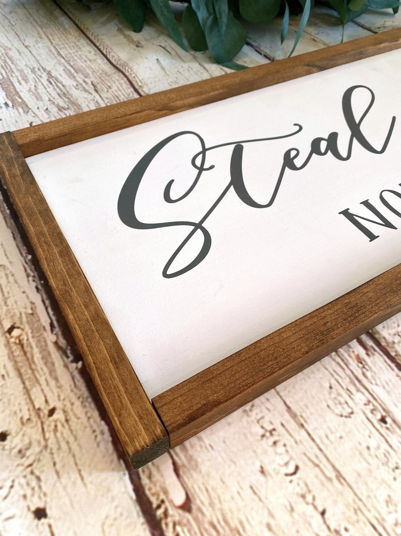 May include: A wooden framed sign with the text "Steal My Sunshine" in a gray cursive font.