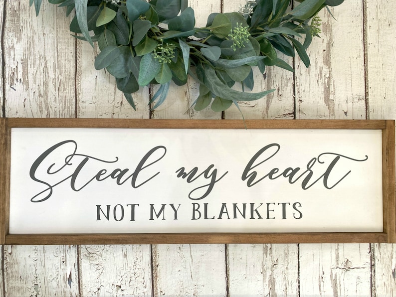 May include: A white wooden sign with a brown frame, featuring the text "Steal my heart not my blankets" in a cursive font.