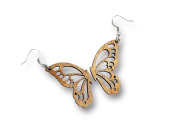 Puede incluir: Un par de pendientes de mariposa de madera con un acabado de madera natural y ganchos plateados.