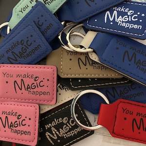 May include: A collection of keychains with different colored leather and the phrase "You make magic happen" written on them.