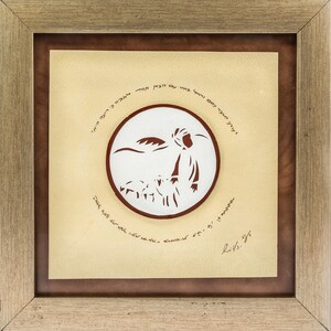 May include: A framed paper cut art piece with a white background and brown text. The art depicts a shepherd with a staff and sheep in a field. The text is in Hebrew and reads "The Lord is my shepherd, I shall not want."